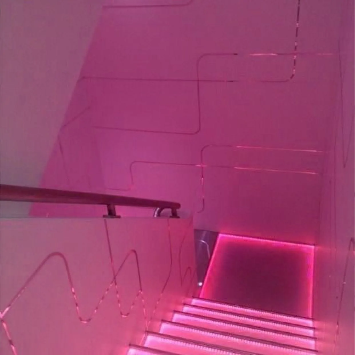 Pink neon-lit stairwell — studio atmosphere