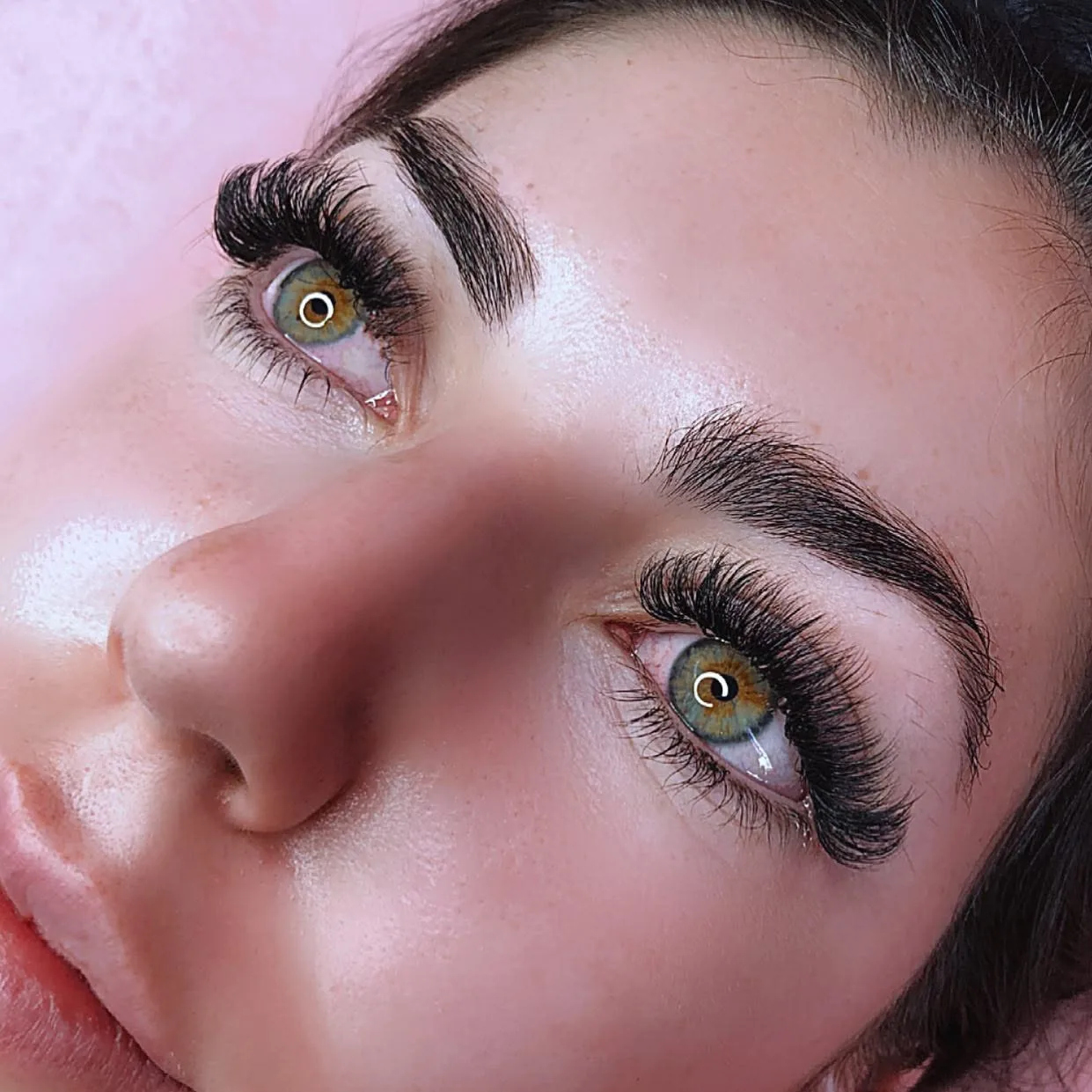 Single-eye macro showing dramatic glam volume extensions on hazel iris