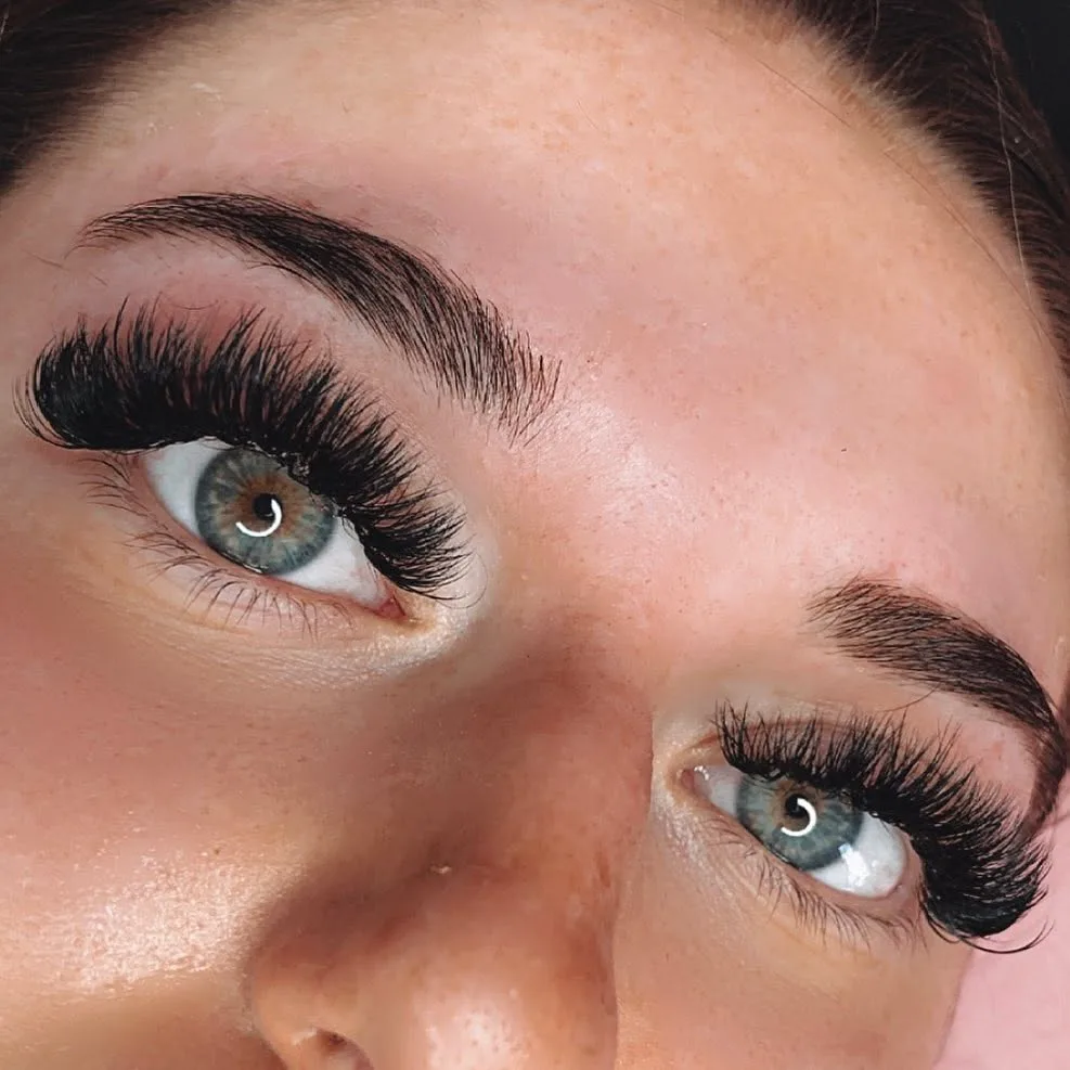 Lifted volume lash set on two blue-green eyes